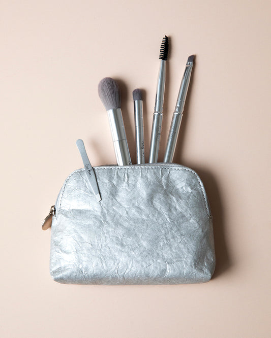 Set de brochas Eco Ere Perez con fondo beige mostrando accesorios. Disponible en BLUMMA