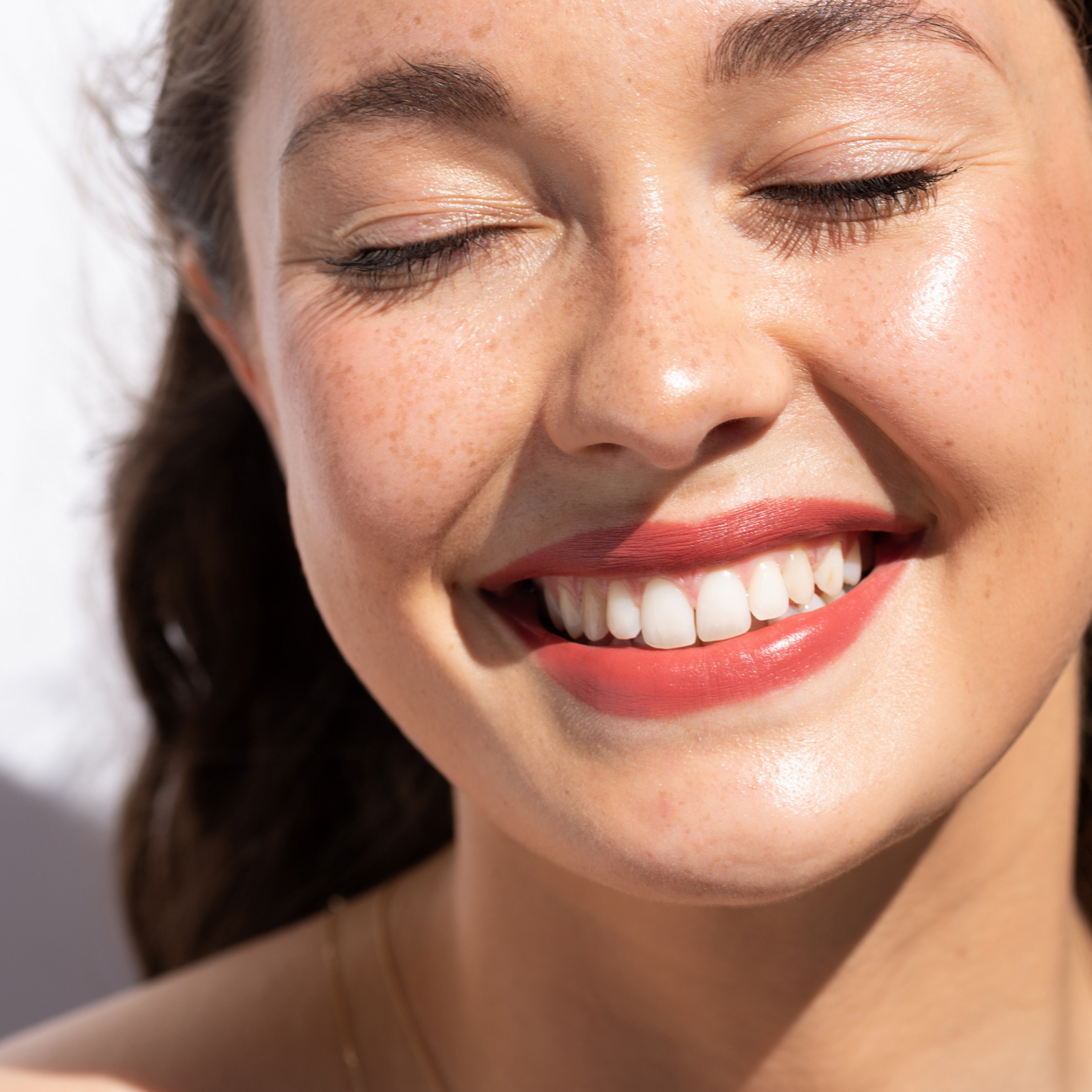 retrato de mujer sonriendo en luz natural y en sus labios el tono charm de crayon con coco ere perez disponible en blumma
