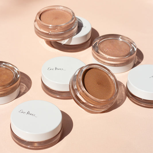 cuatro envases de vidrio abiertos mostrando el producto iluminador de vainilla en tonos falling star y sun halo ere perez disponible en blumma