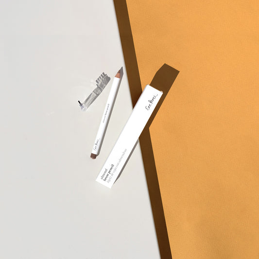 vista aerea en tonos marron y blanco de lapiz de cejas con almendras ere perez con su empaque