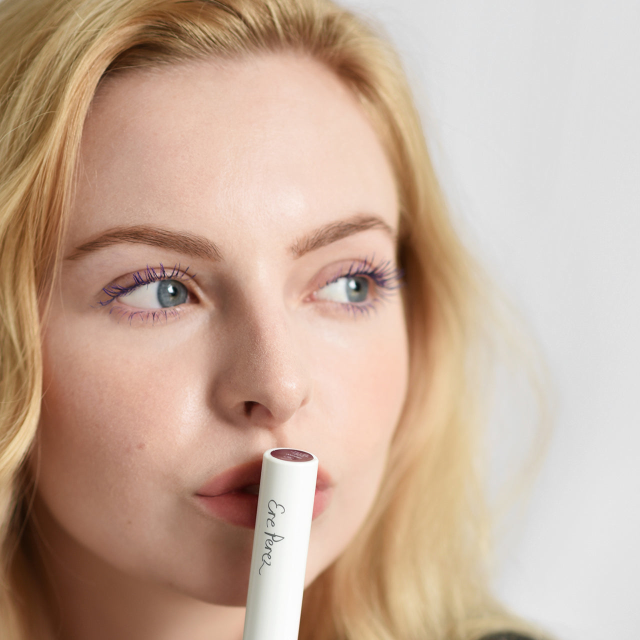 mujer besando mascara de pestanas ere perez tono cafe mostrando sus pestanas definidas