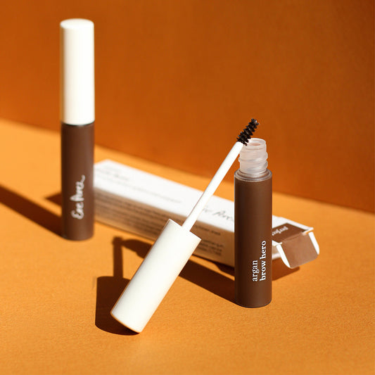 envase sostenible de mascara para cejas con argan vegana ere perez en fondo de colores duotono con su empaque