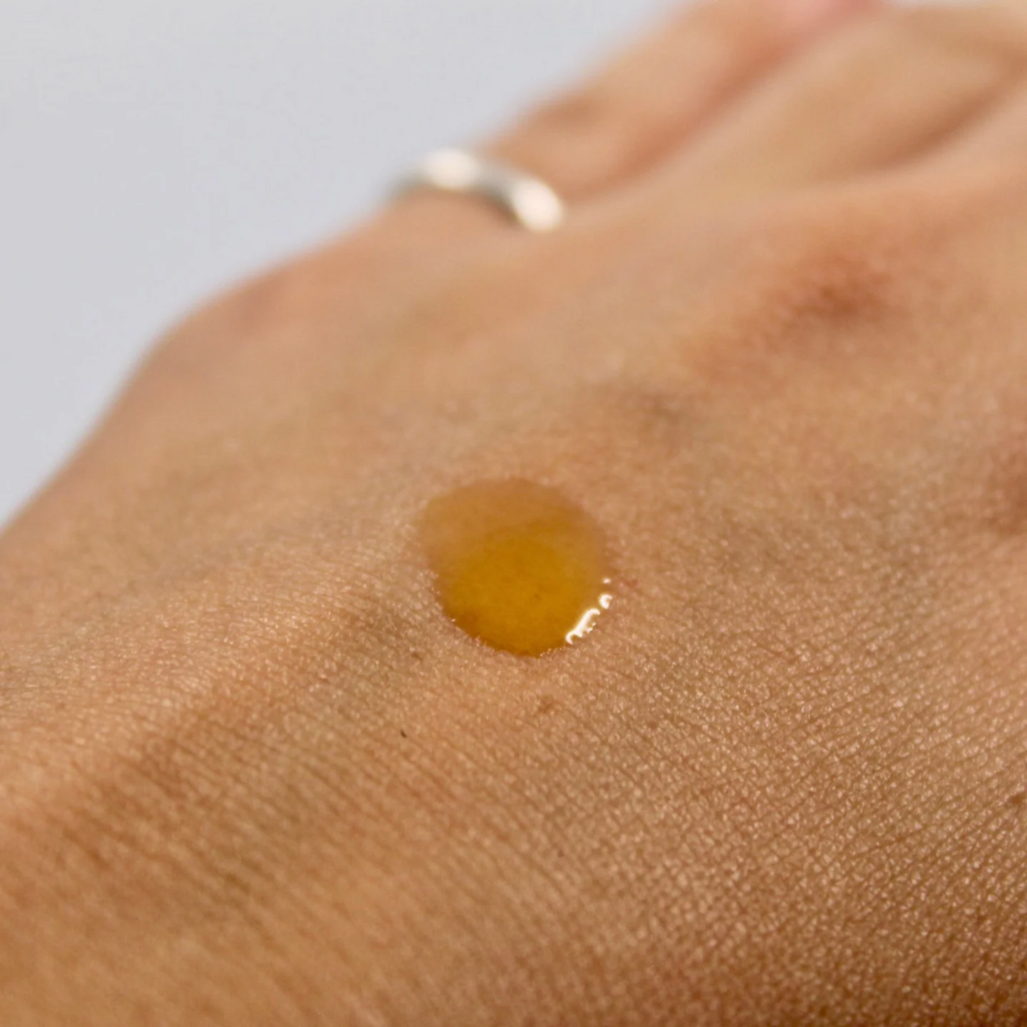 imagen de una gota del suero de retinol 0.15% blauverde aplicada en el dorso de la mano