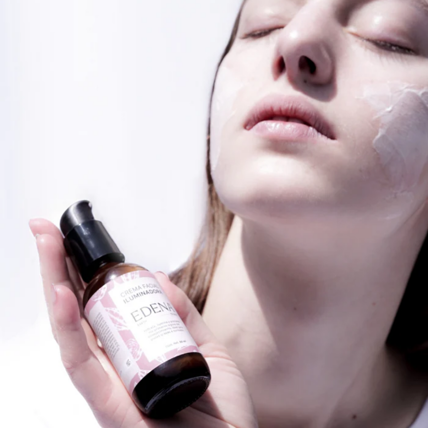 retrato de modelo sosteniendo la crema facial iluminadora de edena