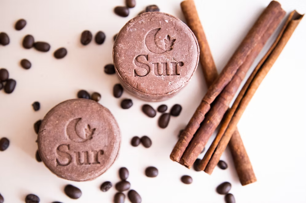 vista en picada del shampoo sólido estimulante con granos de café y ramitas de canela para disponible en Blumma