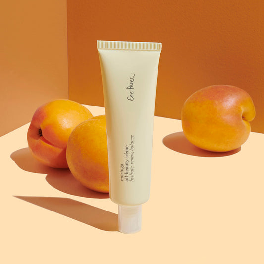 Crema facial con Moringa Ere Perez en fondo de tonos calidos con chabacanos disponible en BLUMMA