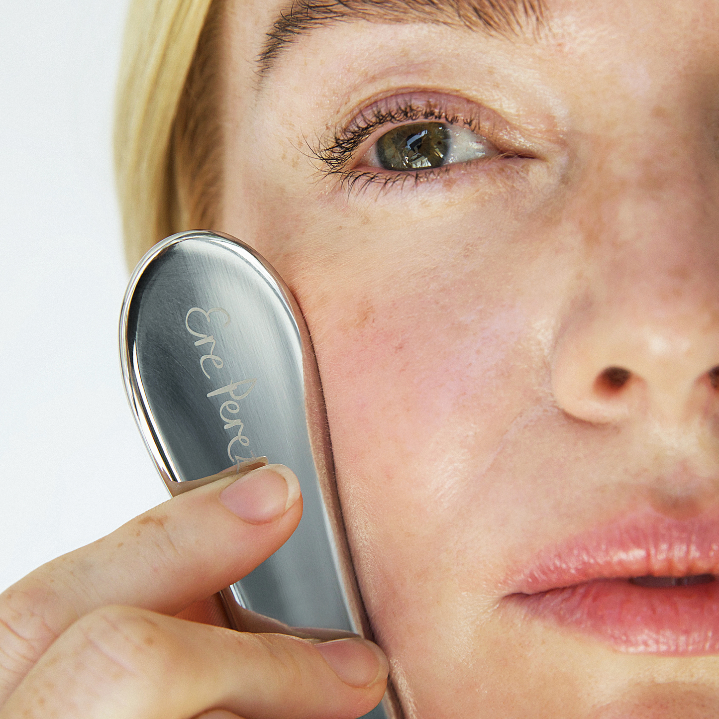 modelo usando gua sha facial de acero inoxidable Ere Perez disponible en Blumma