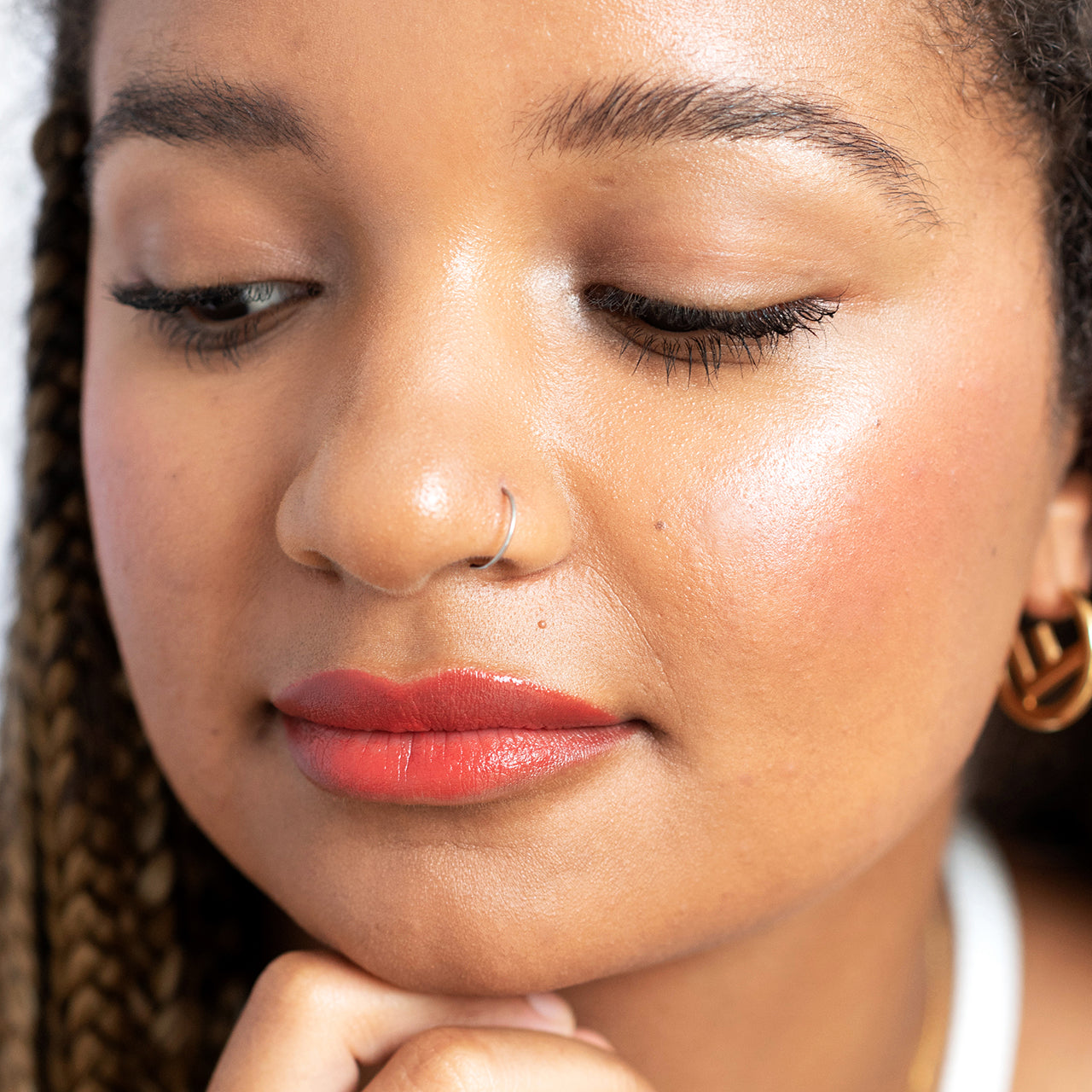 modelo de tez morena con balsamo de zanahoria ere perez tono hello en mejillas y labios