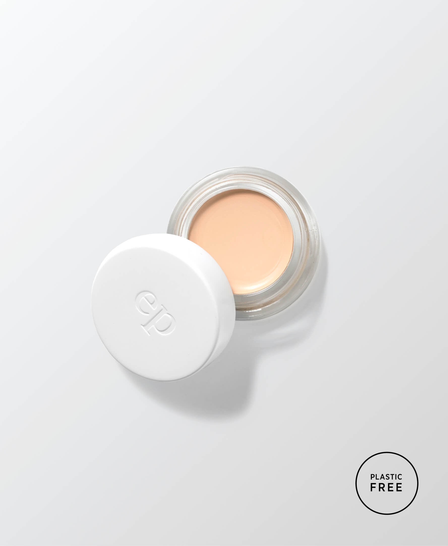 envase de vidrio sostenible abierto mostrando el producto base corrector de arnica en tono latte ere perez en fondo blanco disponible en blumma