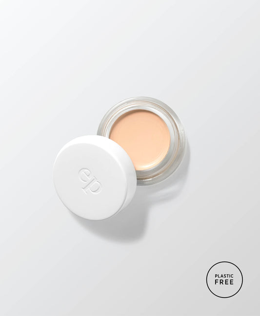 envase de vidrio sostenible abierto mostrando el producto base corrector de arnica en tono latte ere perez en fondo blanco disponible en blumma
