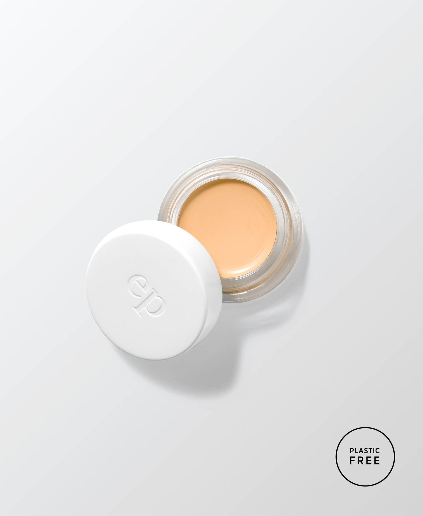 envase de vidrio sostenible abierto mostrando el producto base corrector de arnica en tono honey ere perez en fondo blanco disponible en blumma