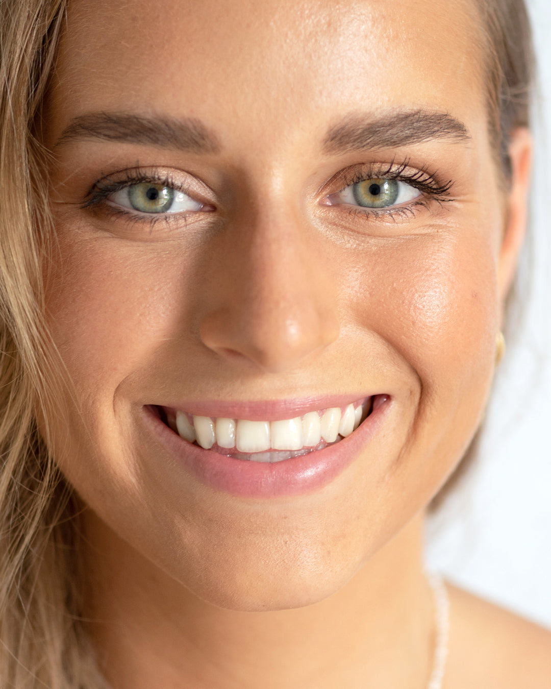 mujer sonriendo con tono roma en sus mejillas de blush y bronceador ere perez disponible en blumma