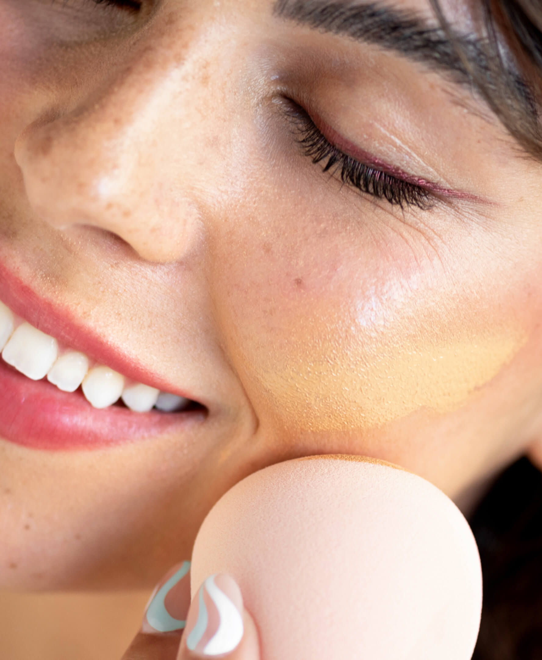 mujer utilizando eco esponja Ere Perez aplicando maquillaje en la mejilla. disponible en BLUMMA