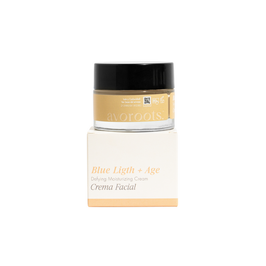 vista frontal de envase de vidrio transparente junto con empaque de la crema facial blue light + age de avoroots en fondo blanco