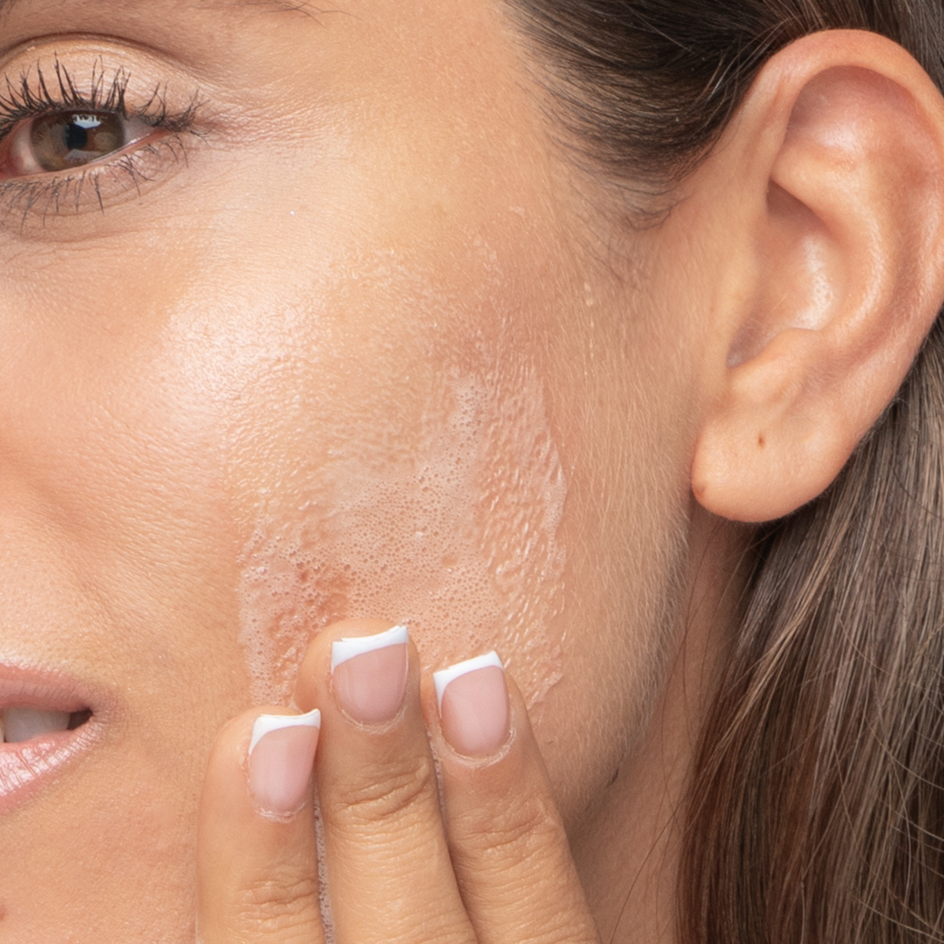 retrao de modelo femenina aplicandose el impiador facial en espuma de avoroots en la mejilla