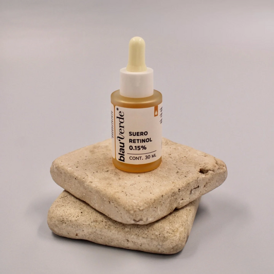 vista frontal de envase de vidrio transparente del suero de retinol 0.15% sobre piedras blauverde 