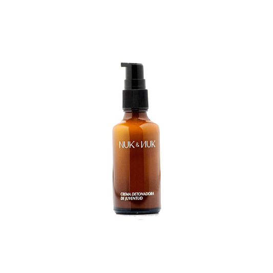 vista frontal de envase de vidrio en tono ambar de la crema facial nuk y nuk