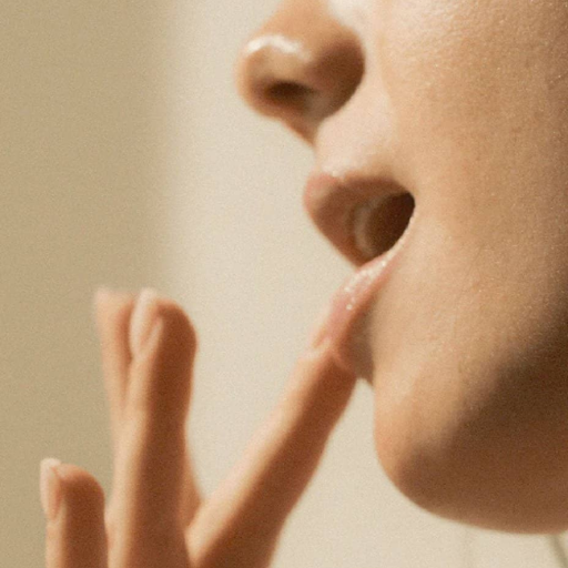 modelo aplicandose el balsamo labial en los labios disponible rice and shine en blumma