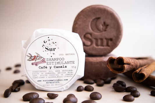 vista frontal del shampoo sólido estimulante café y canela de Sur Biocosmetica acompañado con granos disponible en Blumma